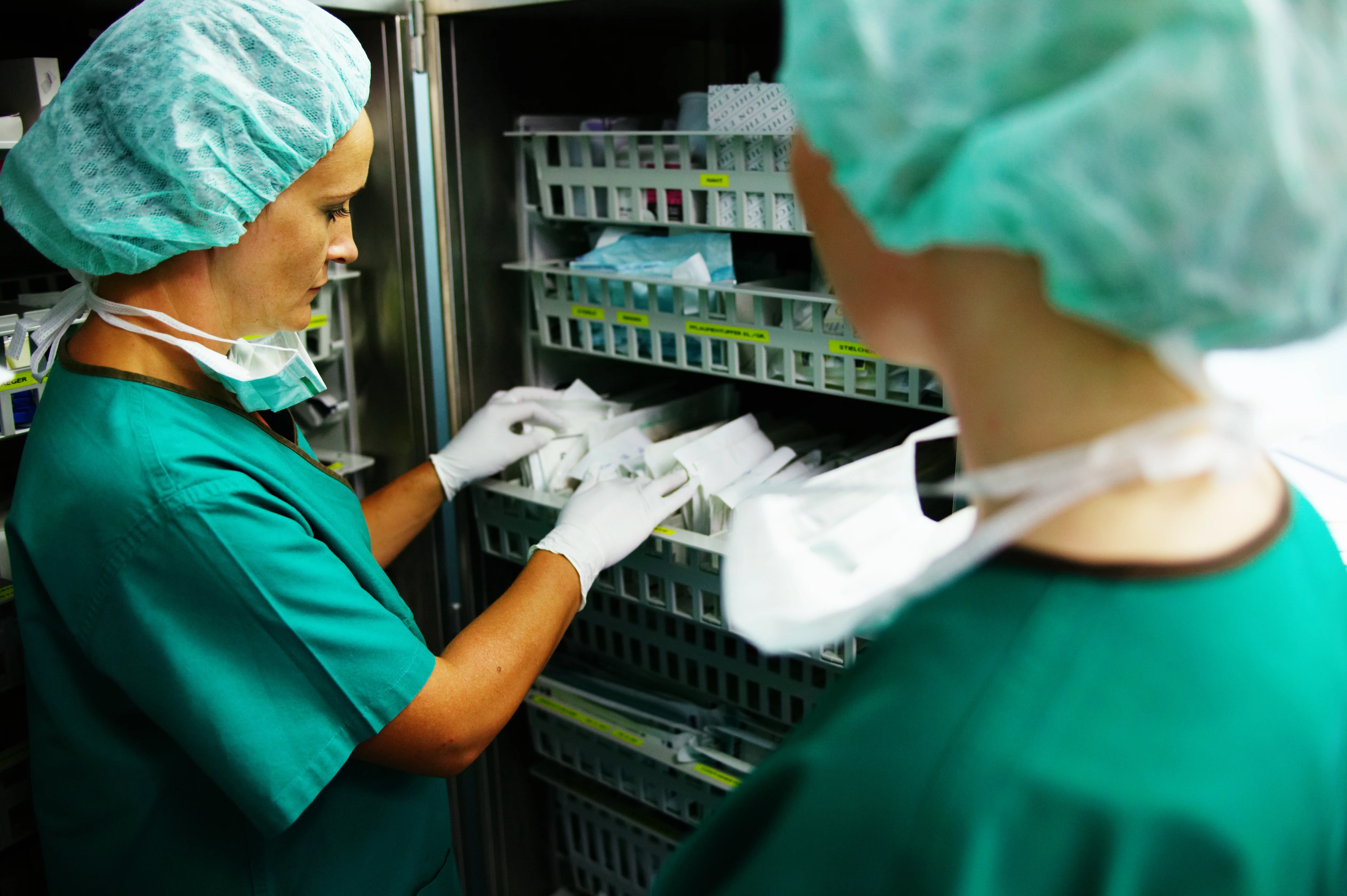 a couple of women in surgical scrubs working in a room