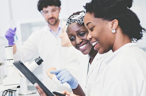 a woman and a man in lab coats looking at a computer