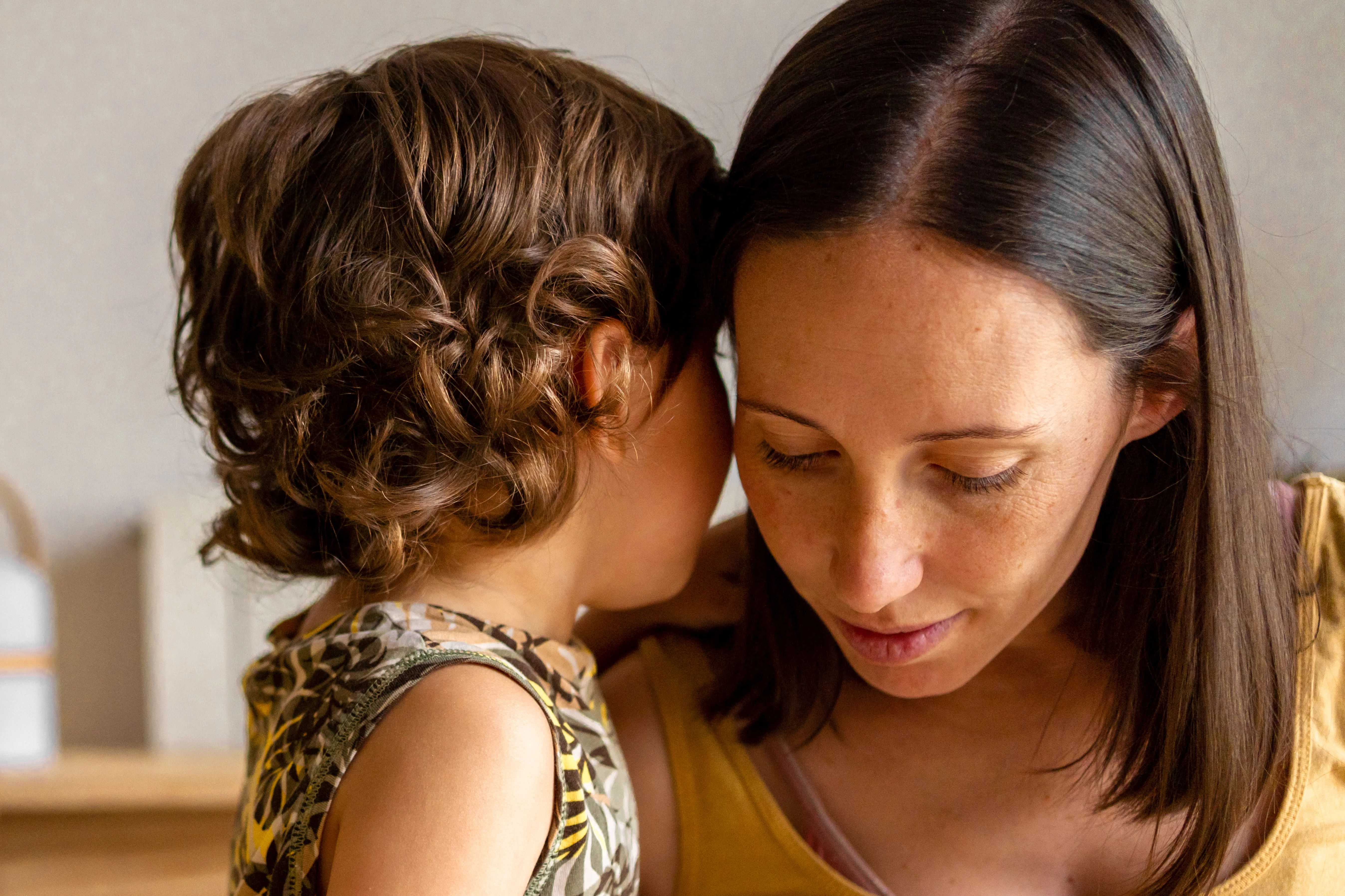 a woman whispering into another woman's ear