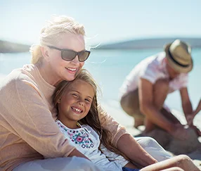 a person and a child sitting on a beach